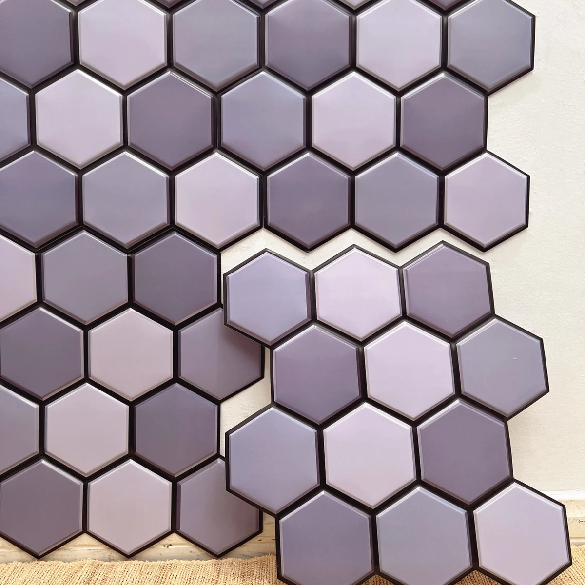 Peel-and-stick backsplash tiles with purple hexagon pattern in a staggered grid