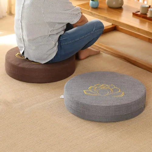 Round linen meditation cushions in brown and grey with lotus embroidery for mindful yoga practice.