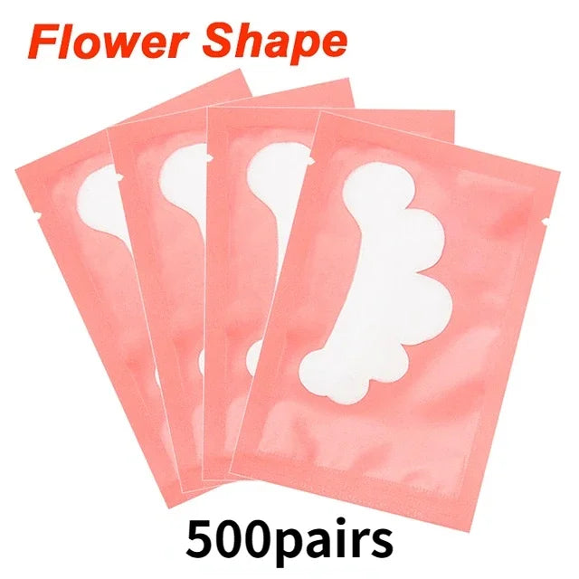 Flower-shaped gel under-eye patches in pink individual sachets for eyelash extension application.