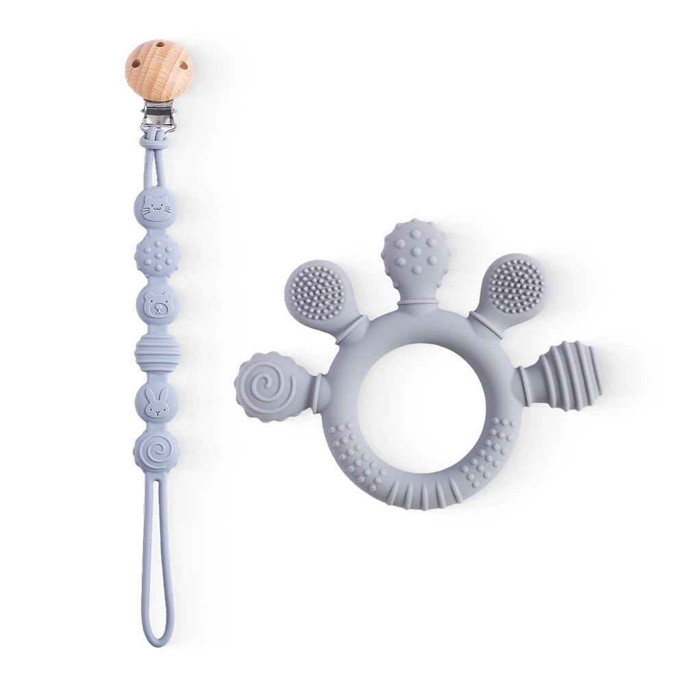 Grey silicone baby teething ring toy with matching pacifier clip for baby teething relief.
