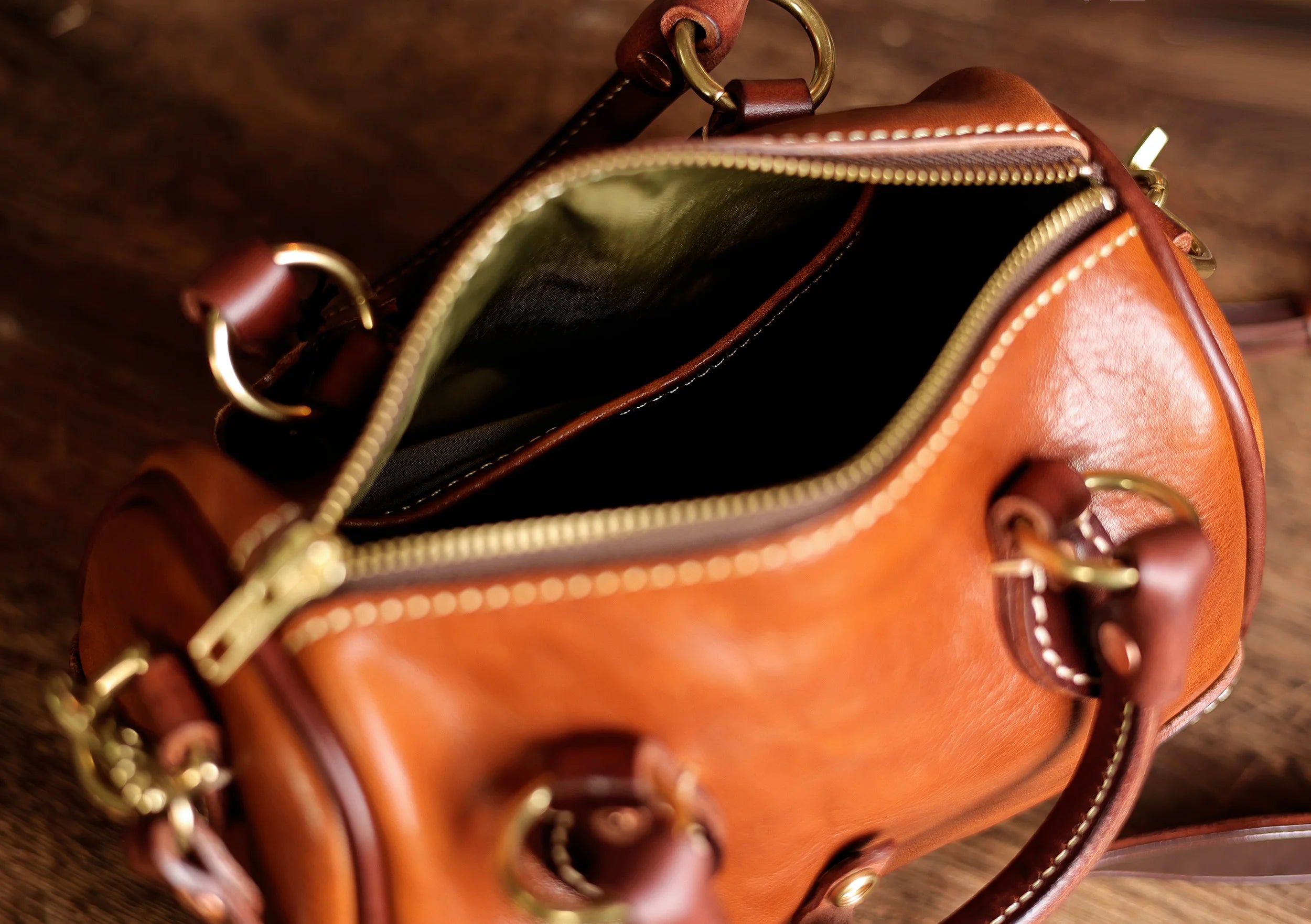 Vintage PNDME small brown genuine cowhide leather designer handbag with brass hardware and zip-top opening.