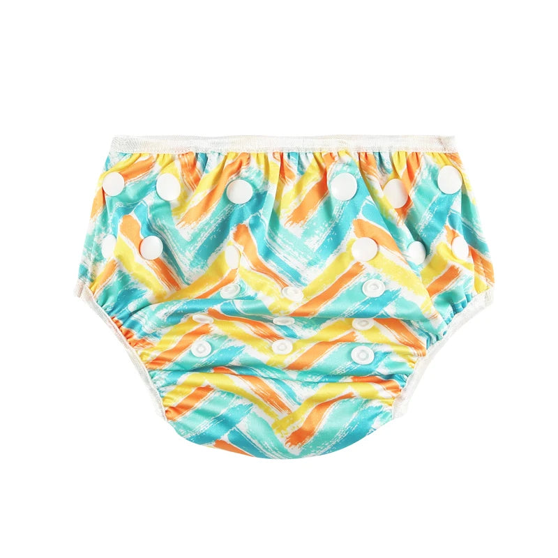 Reusable cloth baby diaper with adjustable snaps and a colorful teal, orange, and yellow chevron brushstroke print.
