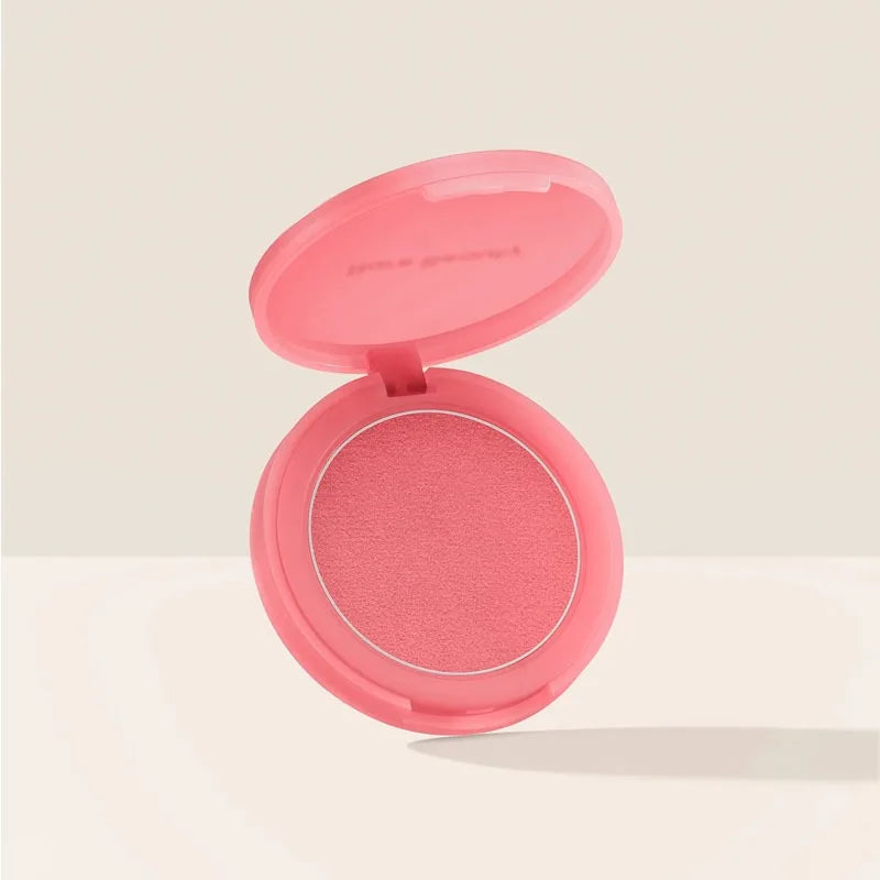 Rare Beauty soft pink powder blush in a round, open compact with a smooth, matte finish.