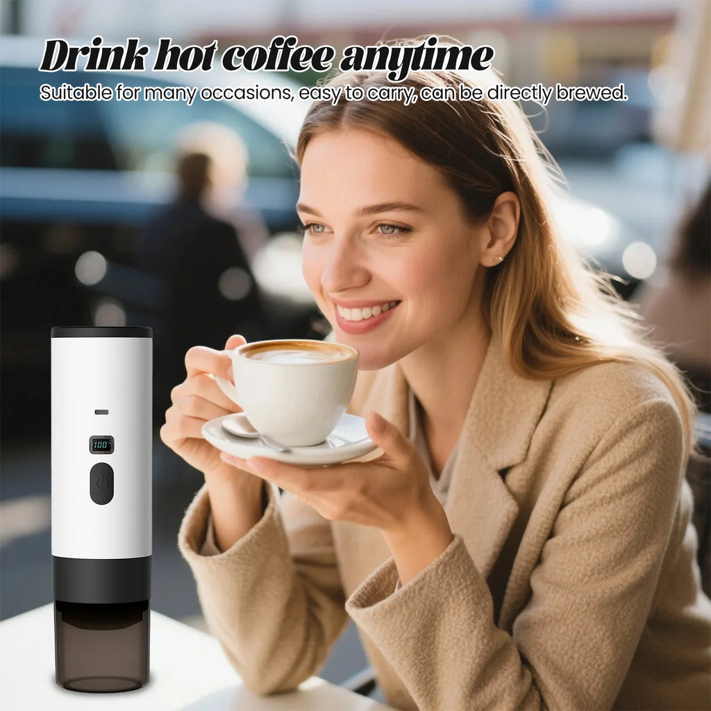 Portable white electric coffee maker with digital temperature display next to woman drinking coffee in a cafe.