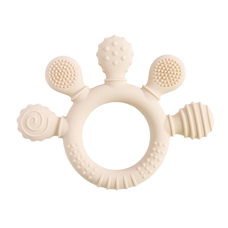 Beige silicone baby teething ring with textured sensory surfaces to soothe gums.