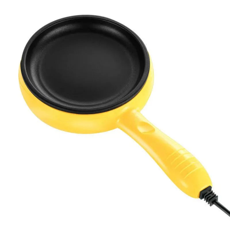 Yellow electric egg cooker pan with black non-stick surface and power cord at handle.