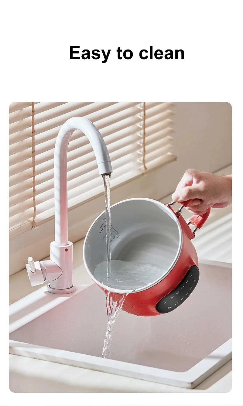 Red electric cooking pot being rinsed with water, showing easy-clean inner basin