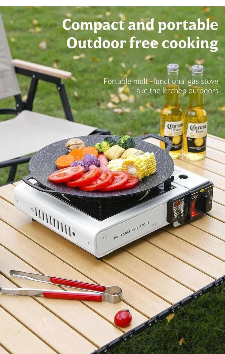 Portable gas stove grilling vegetables with blue flame on a wooden outdoor table
