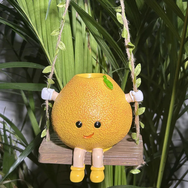 Mini hanging succulent planter, yellow character face with legs, holding a small plant on ropes.