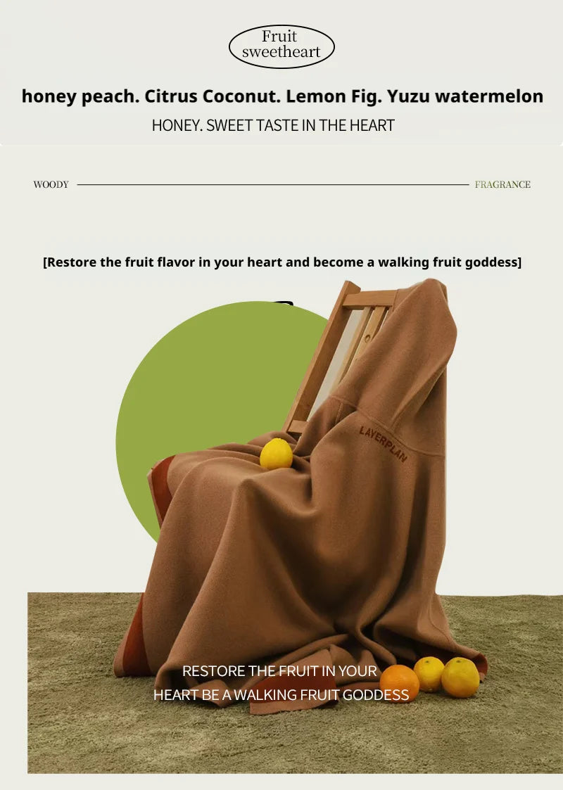 Brown fabric blanket draped over a wooden chair with small yellow citrus fruits on the floor and blanket.