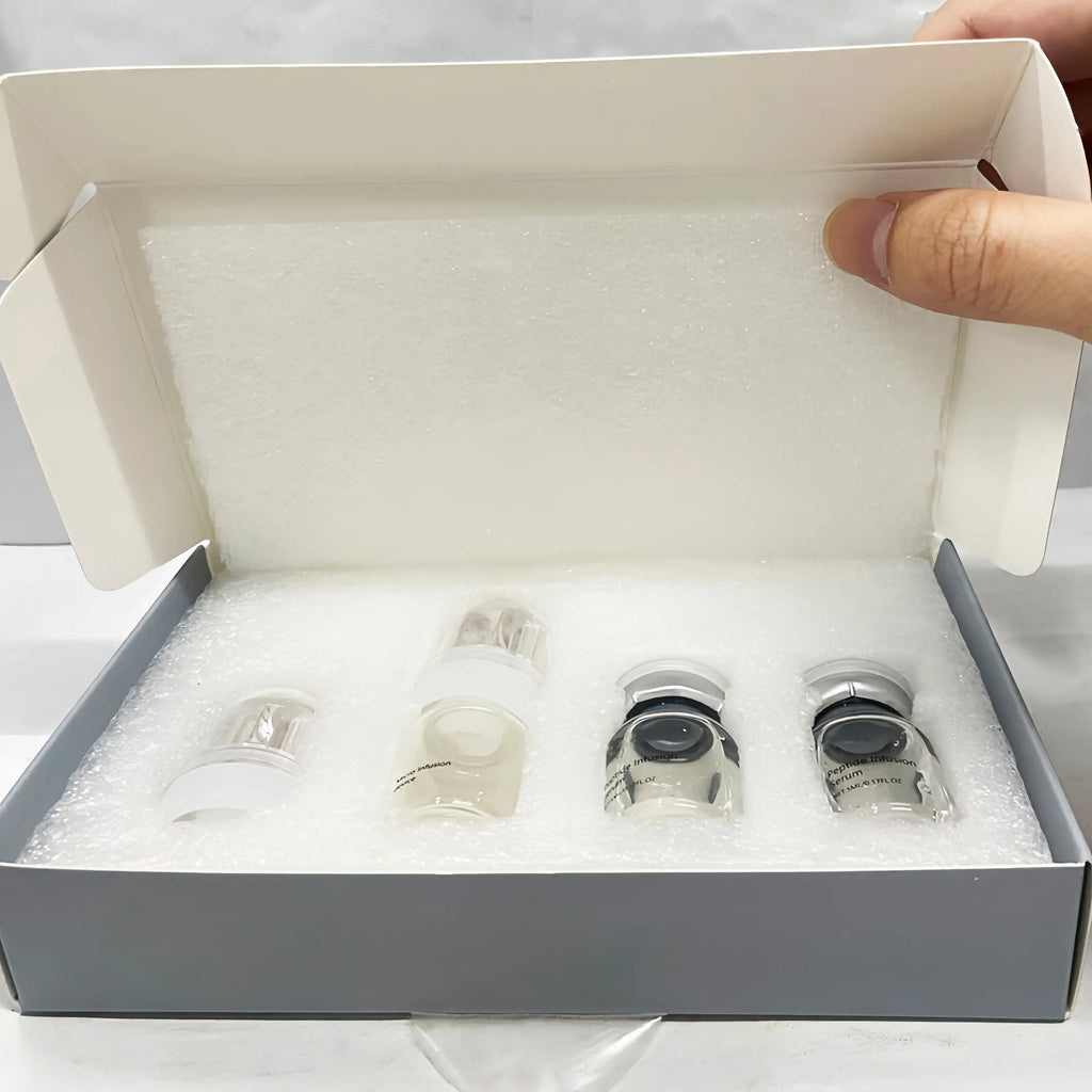 Open box containing four small, clear glass serum vials with silver caps in a white foam protective insert.