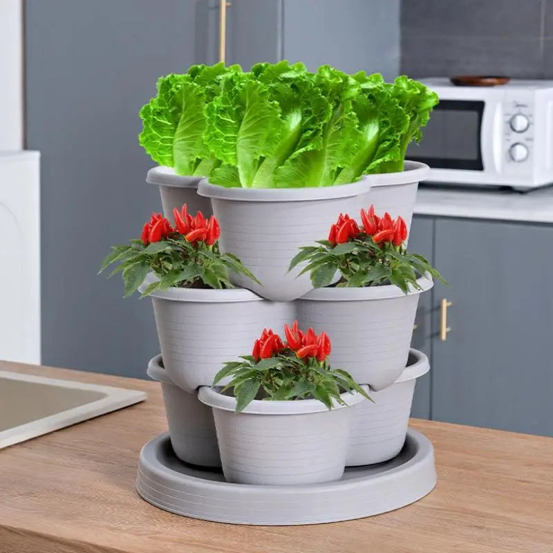 White stackable planter pots on gray tower tray with bright green lettuce and red flowers