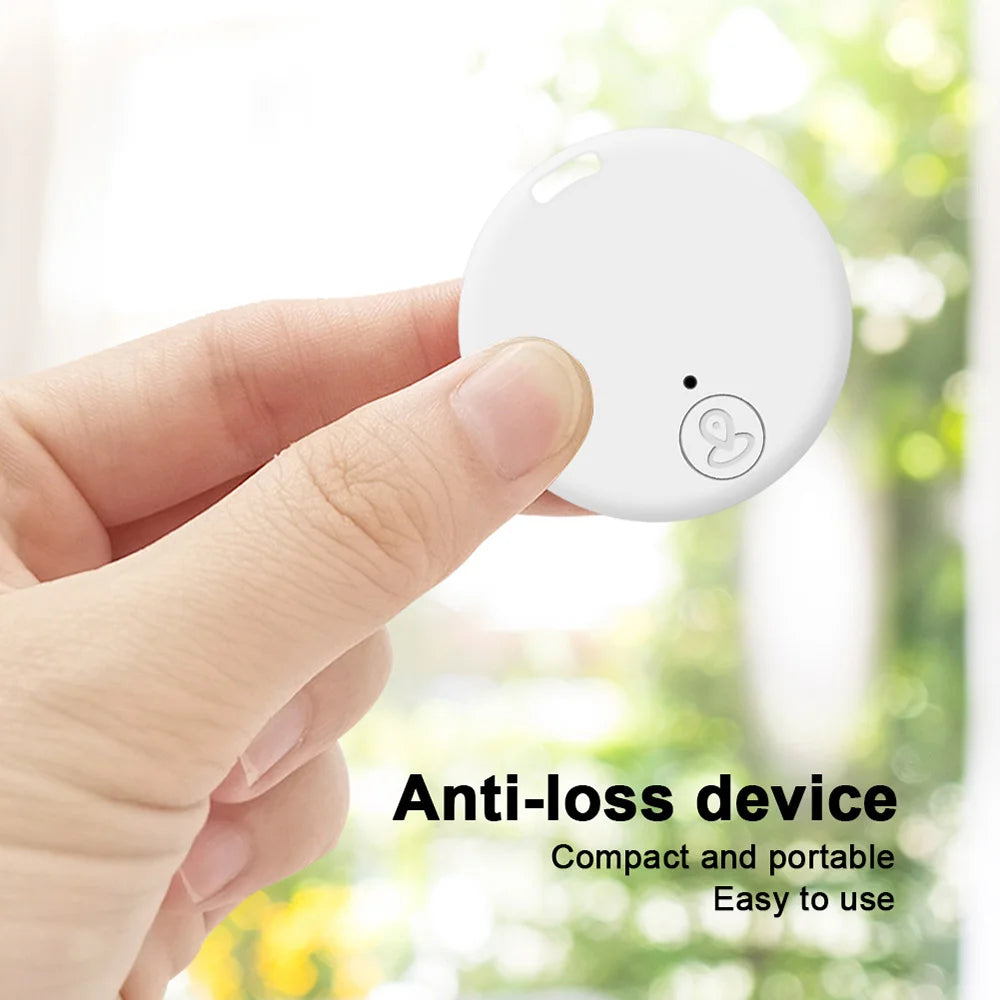 White mini Bluetooth GPS pet tracker held in hand for easy anti-lost monitoring of dogs, cats, and keys.