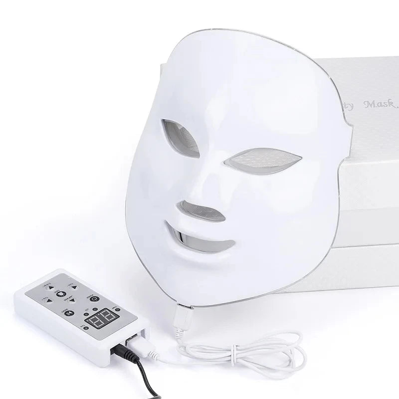White LED light therapy facial mask with a digital handheld control unit and power cable for skincare treatments.