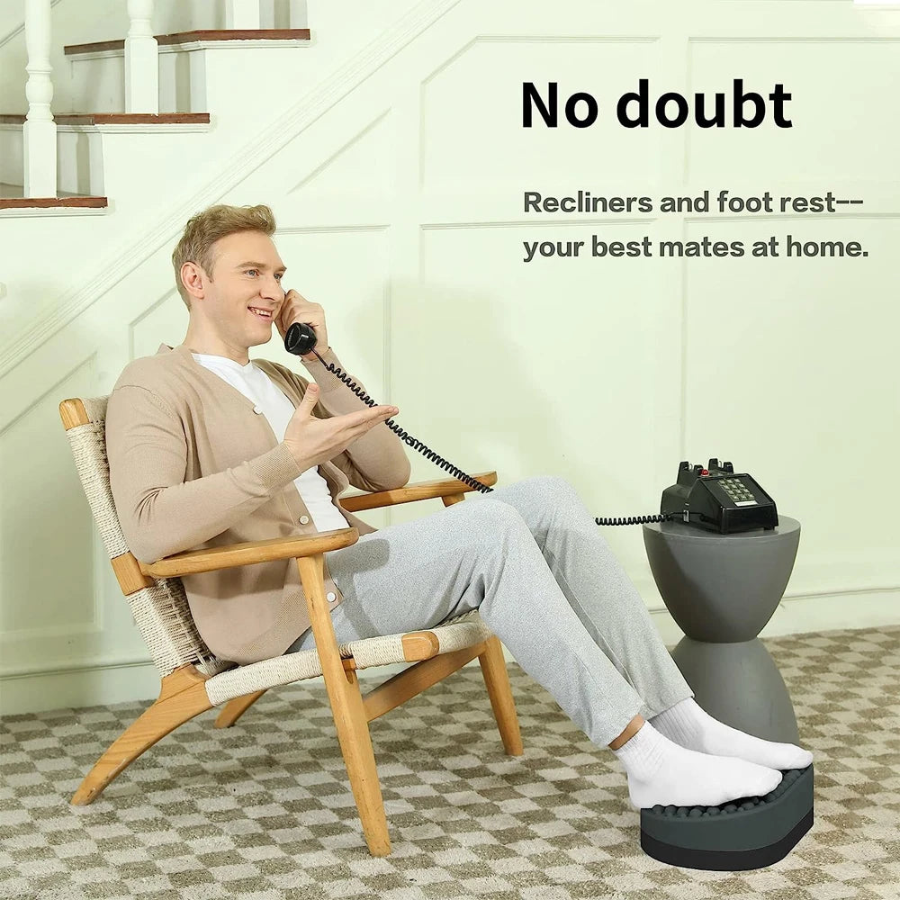 Man using gray silicone foot rest stool for plantar fasciitis relief while sitting in a chair at home.