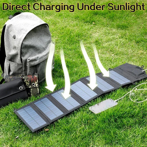 Foldable black solar panel charging a smartphone on green grass next to a grey backpack.