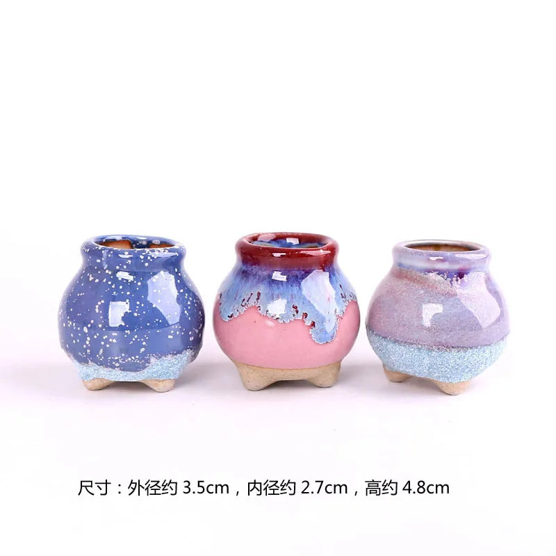 Three mini ceramic succulent pots in blue, pink-red, and lavender glazes, rounded feet