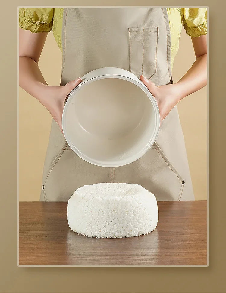 White mini electric rice cooker with inner pot on top, hands holding the lid