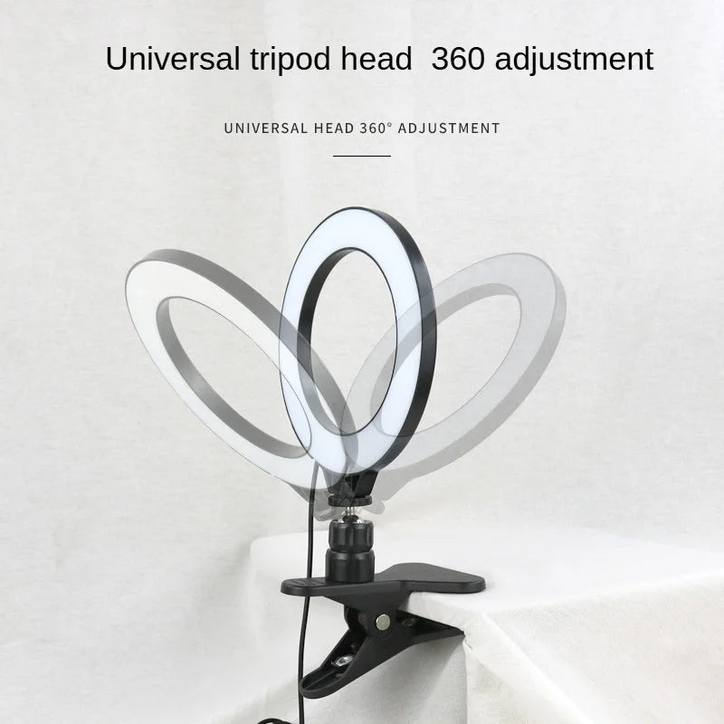 Black clip-on ring light with 360-degree adjustable tripod head for mounting on desks or surfaces for photography.