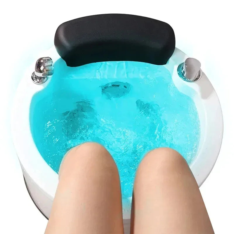 Hydro-massage foot spa with blue water, black headrest, and chrome jet fixtures