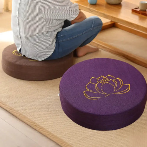 Purple and brown round linen meditation cushions with lotus embroidery for mindful yoga practice.
