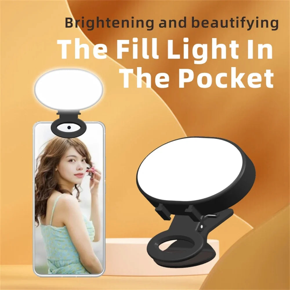 Small circular LED clip-on fill light with black casing, designed to attach to a smartphone for better photography.