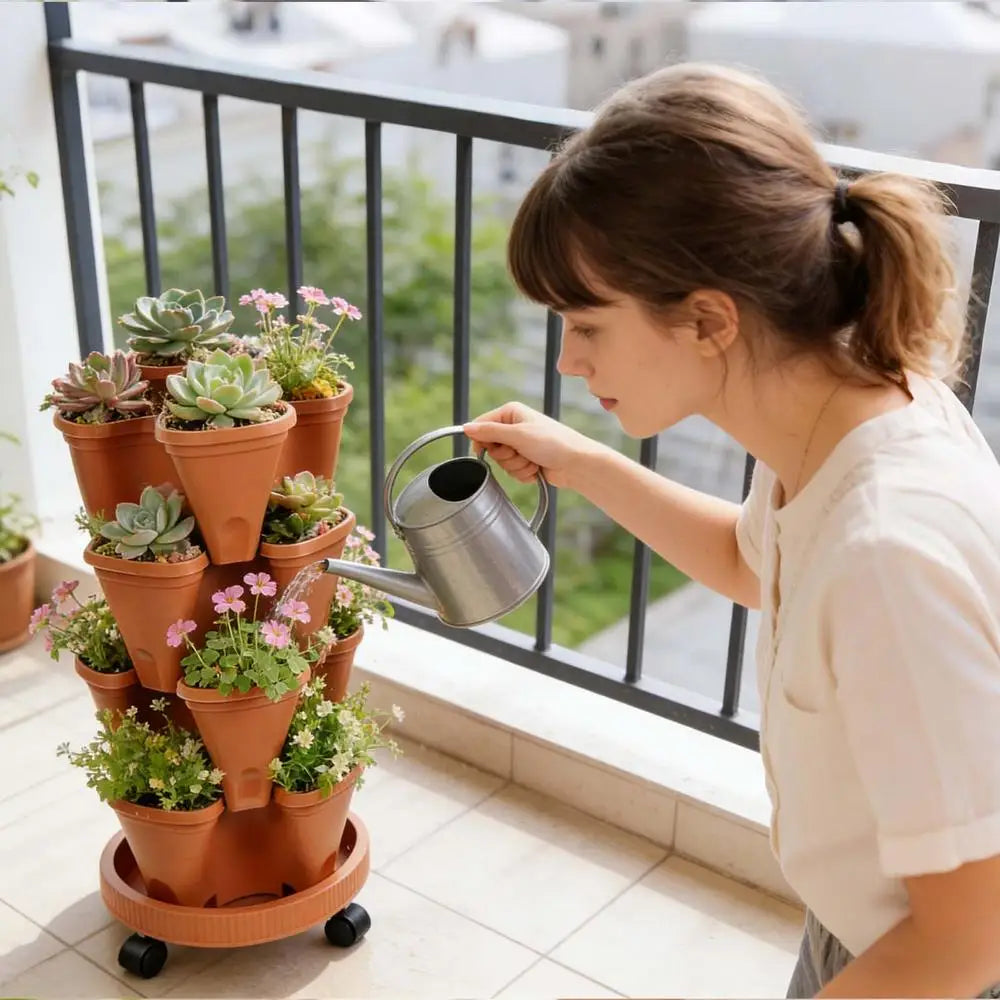 Orange plastic vertical planter tower with stacked pots of succulents as a person pours from a watering can