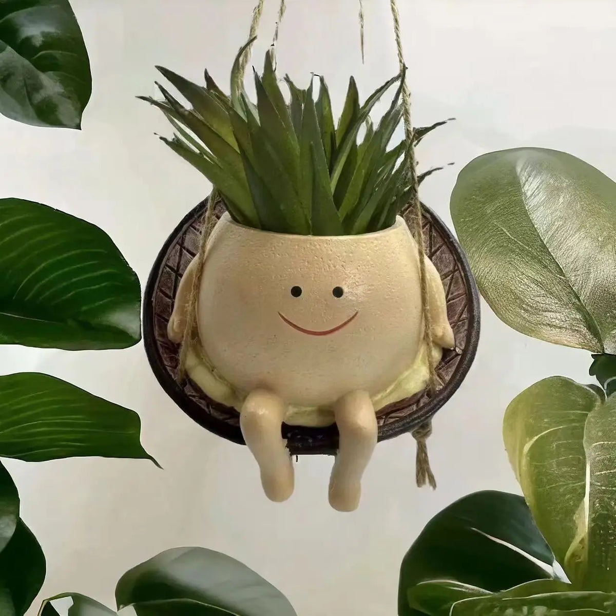 Mini hanging succulent planter, cream character with big grin and upright succulent in pot.