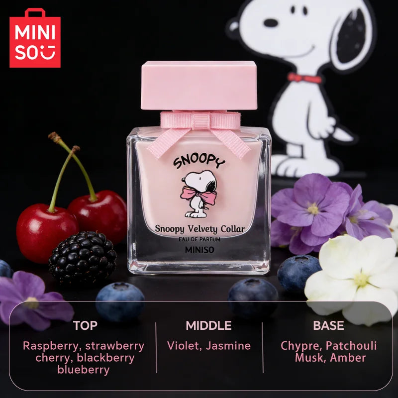Snoopy Velvety Collar eau de parfum in a square pink glass bottle with a pink cap and bow, surrounded by fruit.