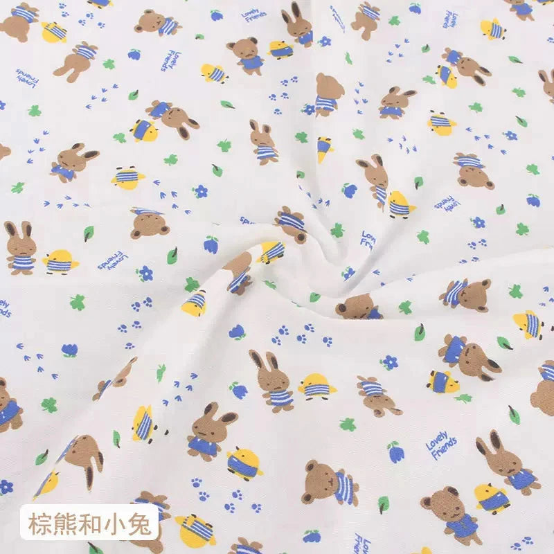 White knit jersey fabric with a pattern of cartoon bears, rabbits, yellow chicks, paw prints, and blue flowers.