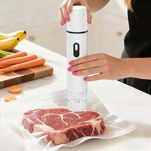 White handheld vacuum sealer pump sealing a meat bag on a kitchen counter