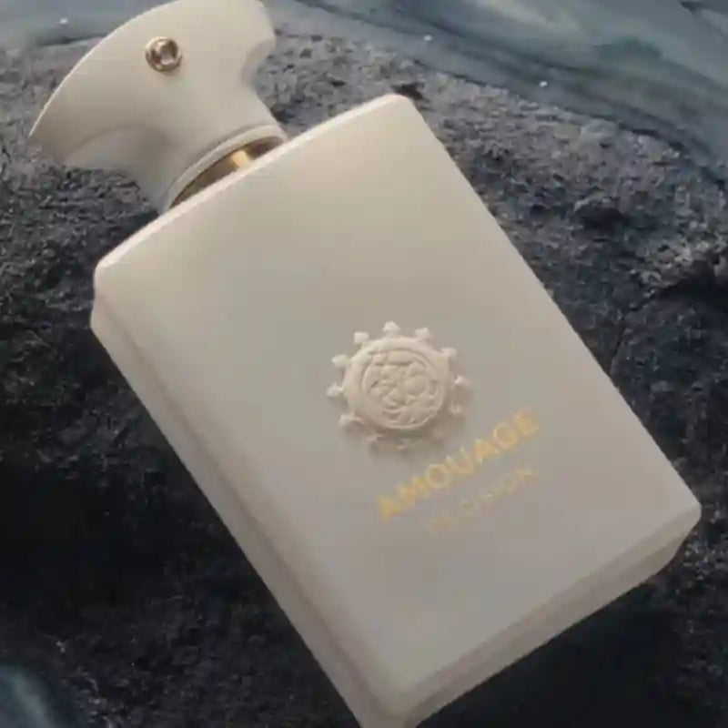 Amouage Decision men's woody aromatic perfume, 100ml. Elegant white rectangular bottle with iconic gold logo emblem.