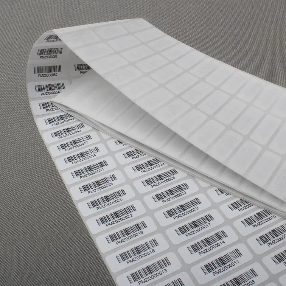 Barcode label roll with multiple white labels and black barcode prints on liner