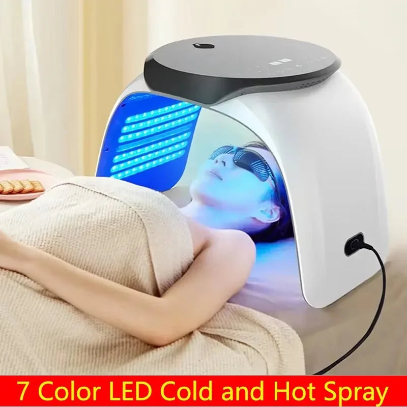 Woman wearing goggles under a 7-color PDT LED light therapy facial rejuvenation arch for acne and anti-aging treatment.