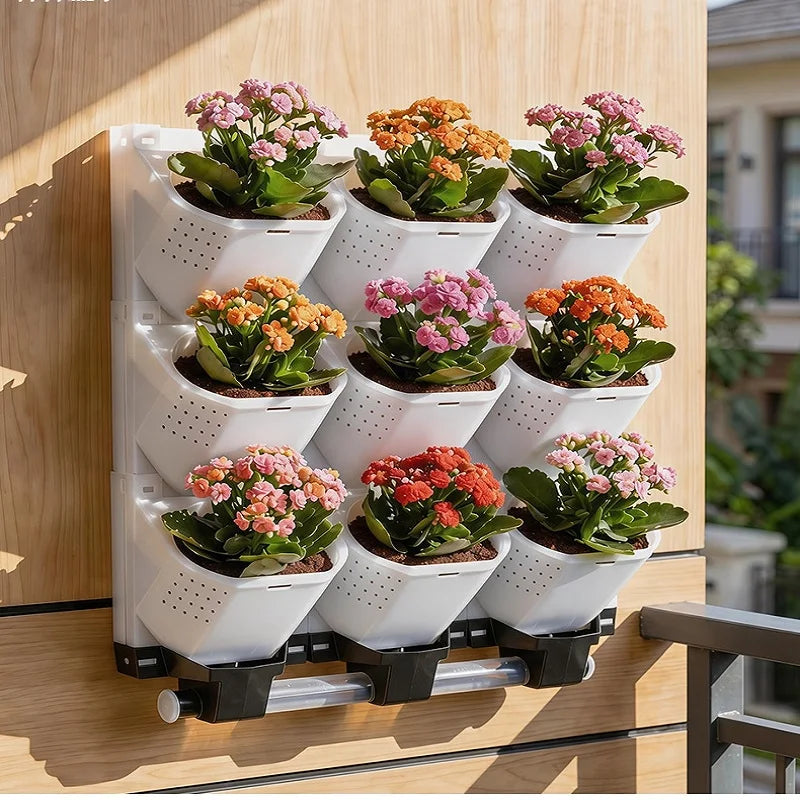White modular vertical garden planter with multiple cups holding colorful flowers