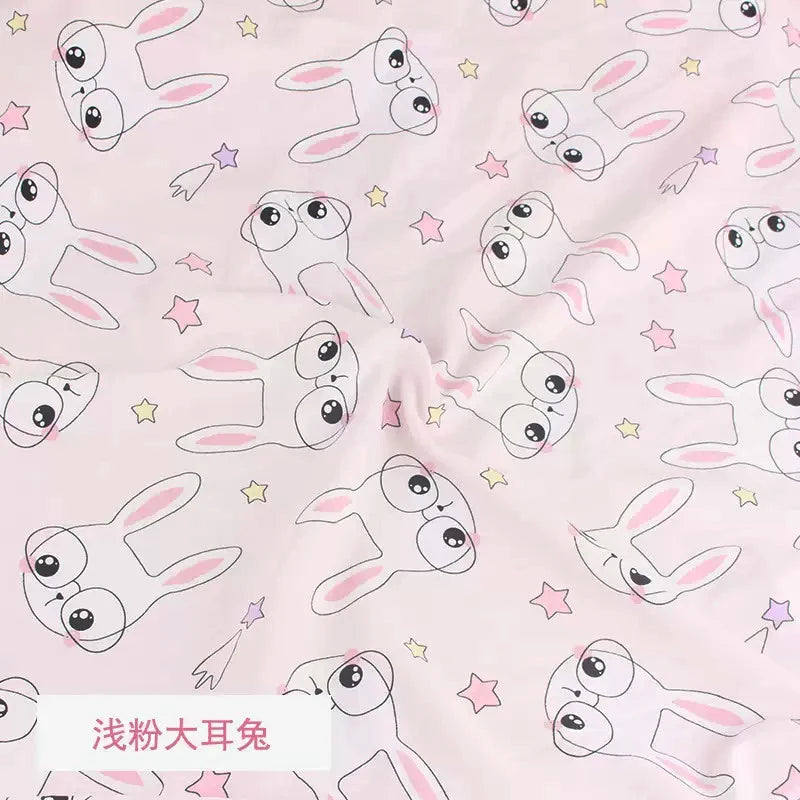 Soft pink knit fabric featuring a repeating pattern of white cartoon bunny faces wearing glasses and colorful stars.