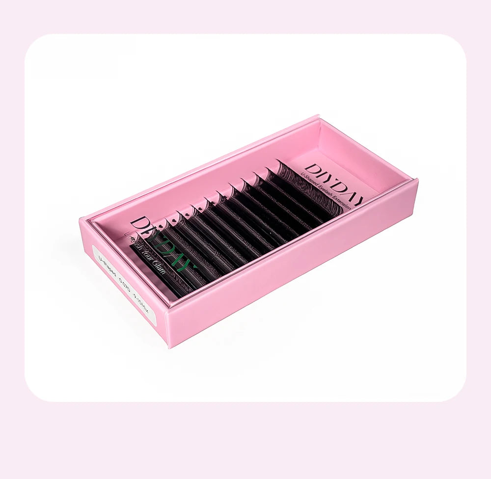 Black DIYDAY YY-shaped PBT eyelash extension strips neatly arranged in a soft pink rectangular storage box.