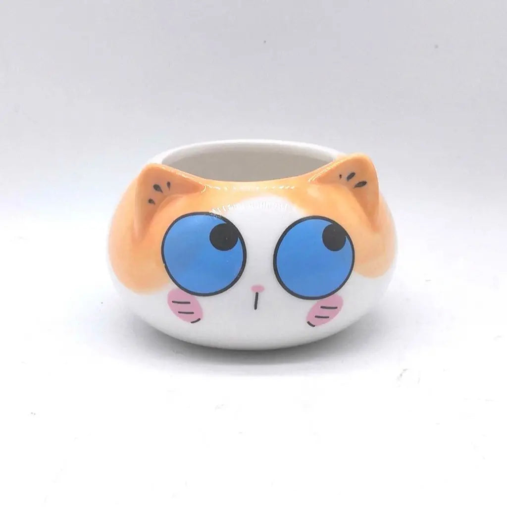 White ceramic kitten-face planter cup with large blue eyes and orange ear details