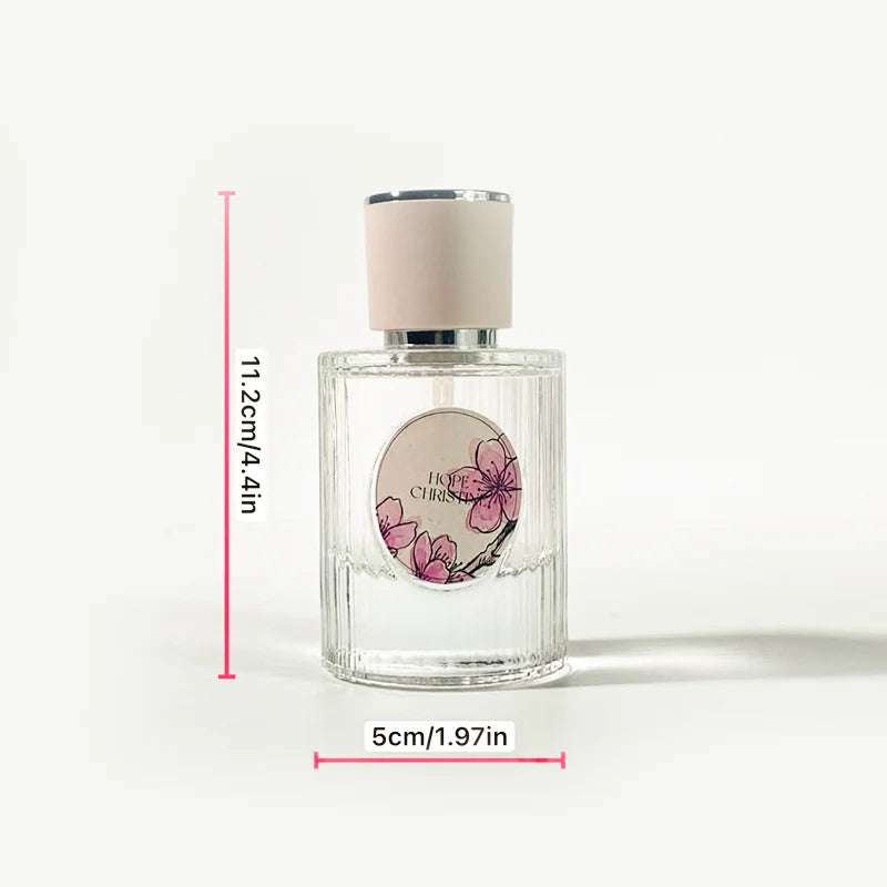 Glass perfume bottle with pink cherry blossom label, pastel cap, and ridged texture, 11.2cm height, floral fragrance.