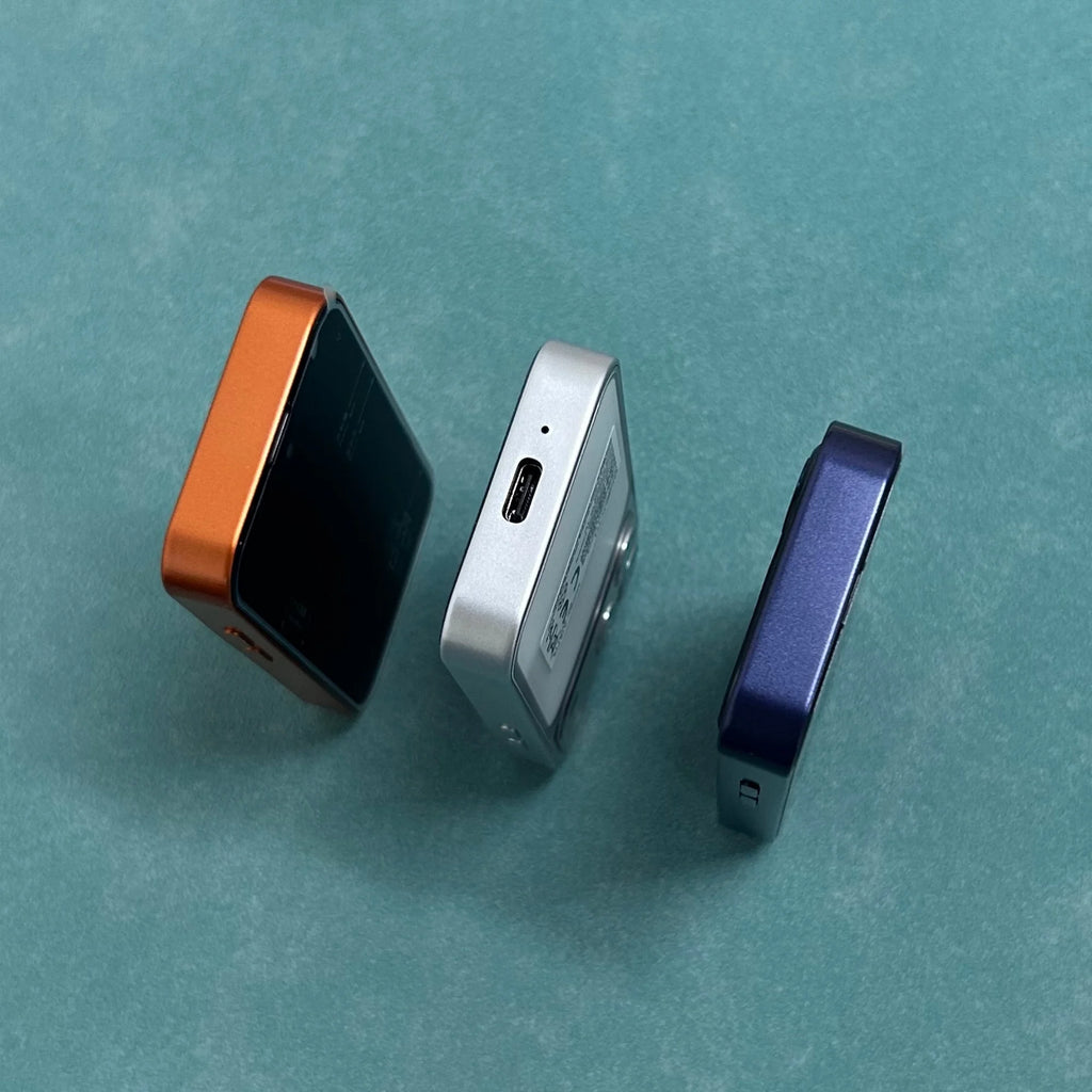 ONEMYTH A18 Pro 4G mini smartphones in orange, silver, and blue, showing Type-C port and side profiles on teal background.