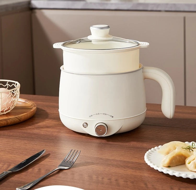 White electric hot pot on countertop with glass lid, side handle, and heat dial