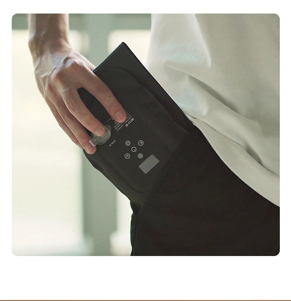 Black foldable LED light panel with digital display and power port, held in a person's pocket for portable illumination.