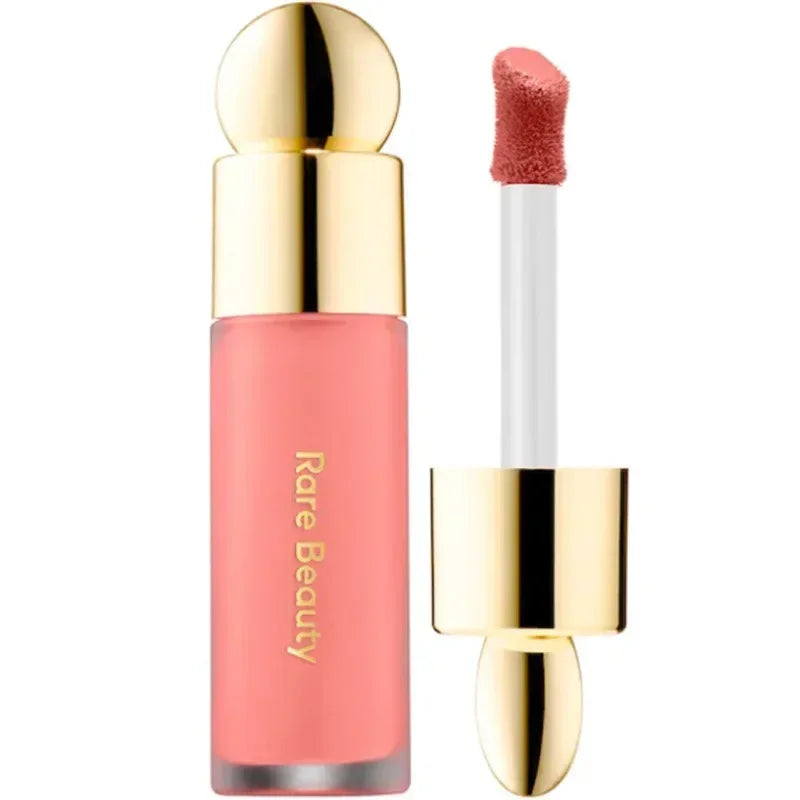 Rare Beauty matte liquid lipstick in a rich coral shade with a smooth, moisturizing applicator and gold cap.