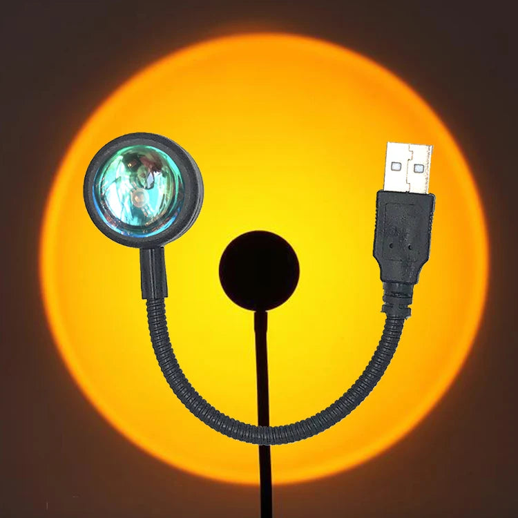 Sunset lamp with a flexible black cord, round glass lens, and USB connector to project a circular orange light.