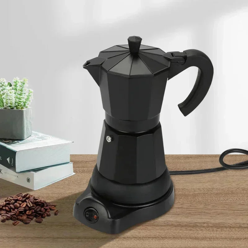 Matte black electric moka pot coffee maker with a modern octagonal design on a power base, set on a wooden table.