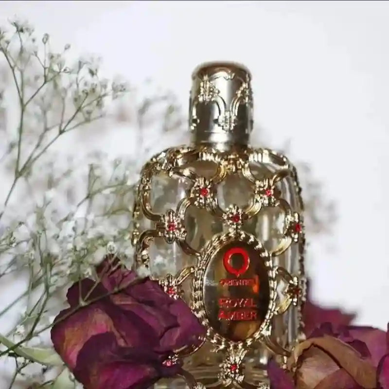 Orientica Royal Amber 100ml EDP: Luxurious unisex amber fragrance in a gold-caged bottle with red jeweled accents.