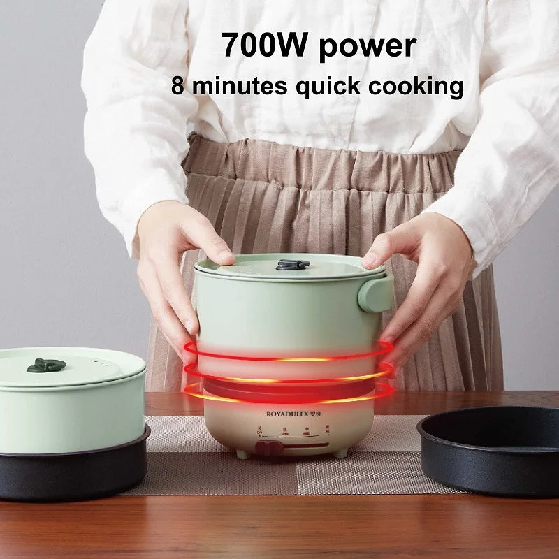 Green electric multi-cooker pot with lid, red heating light glowing under base
