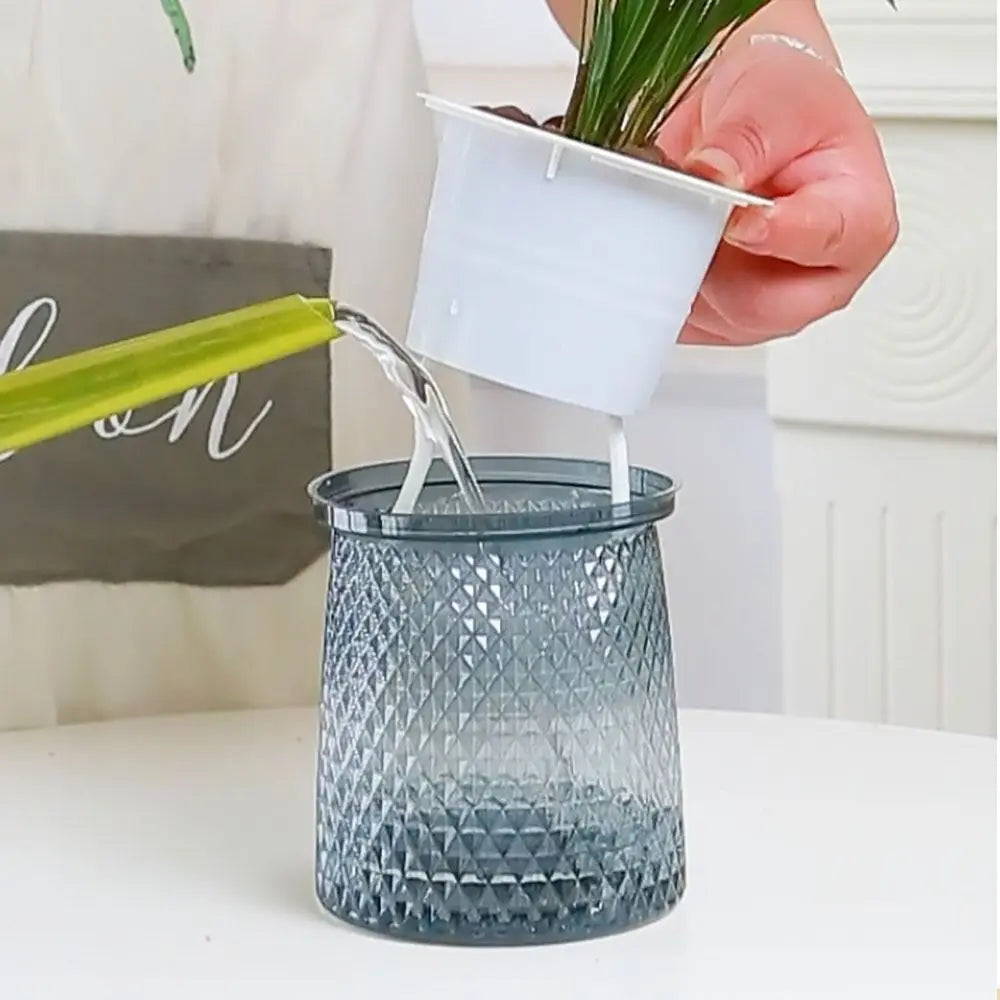 Hand holding inner watering container for a self-watering textured gray plastic plant pot