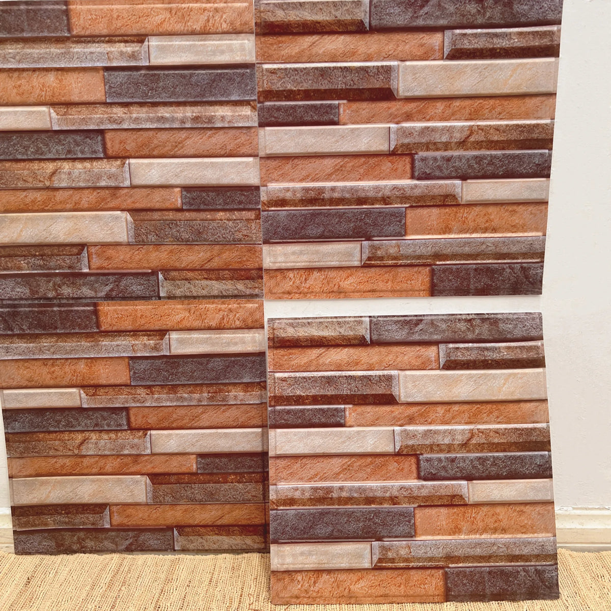 Peel-and-stick backsplash tile sheet with faux brick pattern in orange, brown, and tan