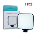 Small, square LED video light with a white panel and black base, standing next to its turquoise and white box.